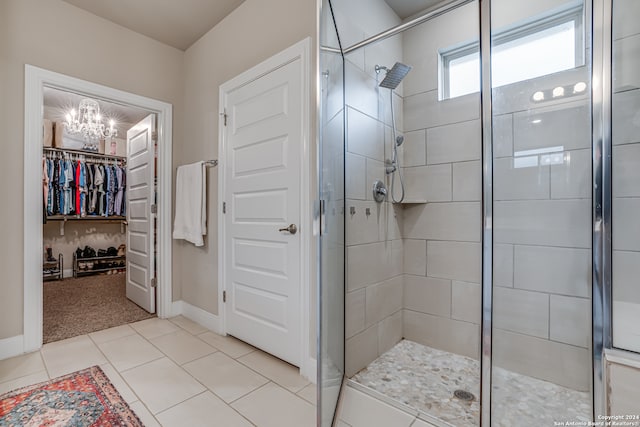 bathroom with a chandelier, tile patterned floors, and a shower with door