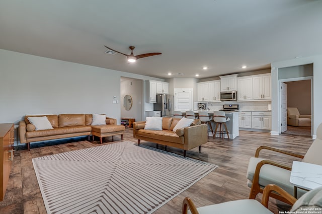 living room with hardwood / wood-style flooring and ceiling fan