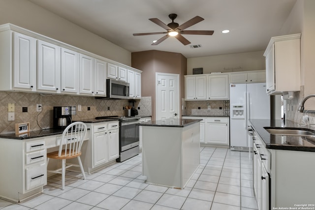 kitchen featuring stainless steel appliances, decorative backsplash, sink, a kitchen island, and white cabinetry