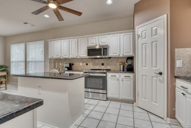 kitchen featuring stainless steel appliances, white cabinets, decorative backsplash, and a kitchen island