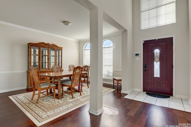 entryway with wood-type flooring and crown molding