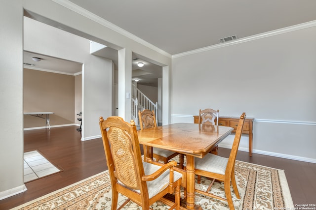 dining room featuring ornamental molding and dark hardwood / wood-style floors