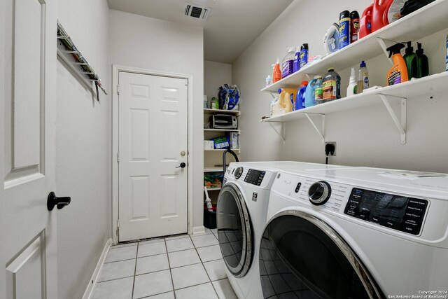 laundry room featuring washing machine and dryer and light tile patterned floors