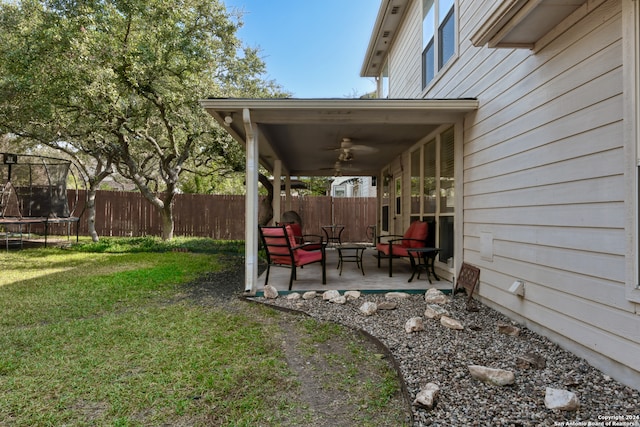 view of yard featuring ceiling fan, a patio, and a trampoline