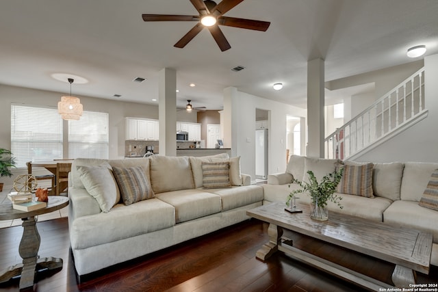 living room featuring dark hardwood / wood-style flooring and ceiling fan