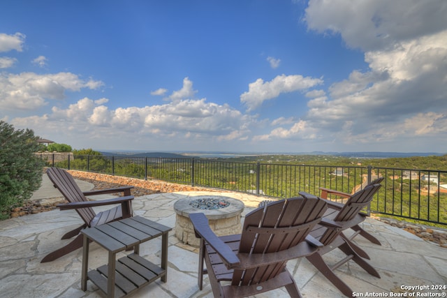 view of patio with an outdoor fire pit and a rural view