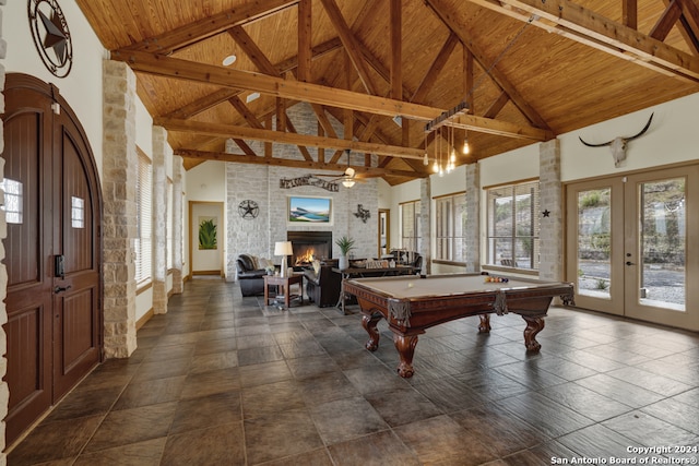 rec room with french doors, beam ceiling, high vaulted ceiling, a large fireplace, and wooden ceiling