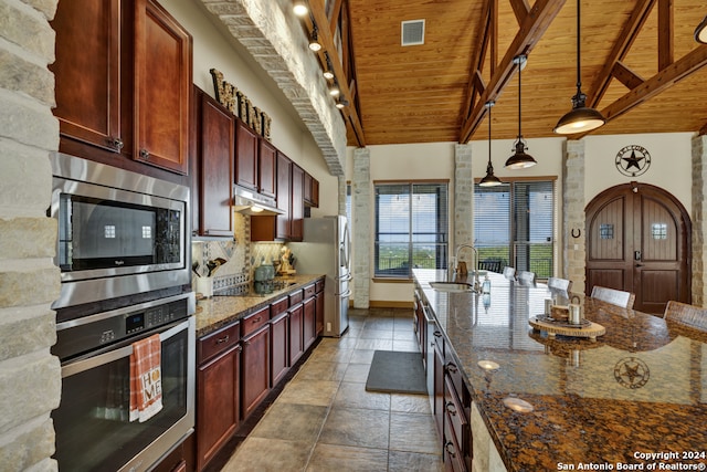 kitchen with wood ceiling, high vaulted ceiling, pendant lighting, appliances with stainless steel finishes, and dark stone countertops