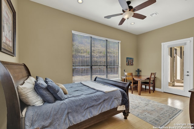 bedroom with ceiling fan, multiple windows, and light hardwood / wood-style flooring