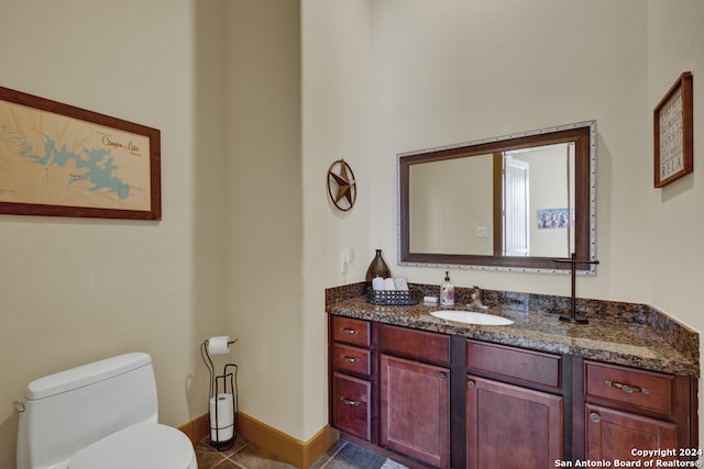 bathroom featuring toilet, vanity, and tile patterned floors