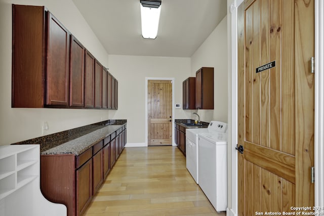 interior space with sink, light wood-type flooring, cabinets, and independent washer and dryer