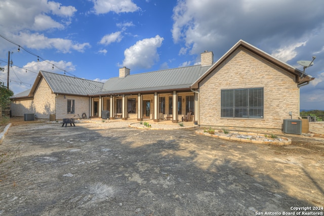 back of house with central AC unit and a patio