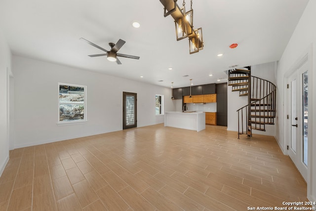 unfurnished living room with ceiling fan, sink, and light hardwood / wood-style flooring