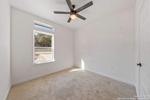 unfurnished room with light colored carpet and ceiling fan