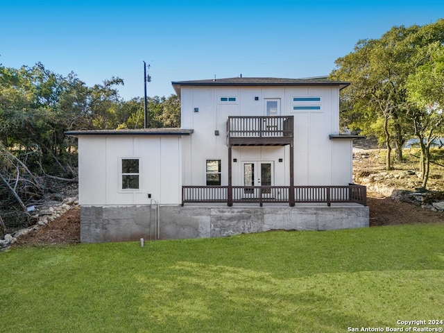 back of house with a balcony and a lawn