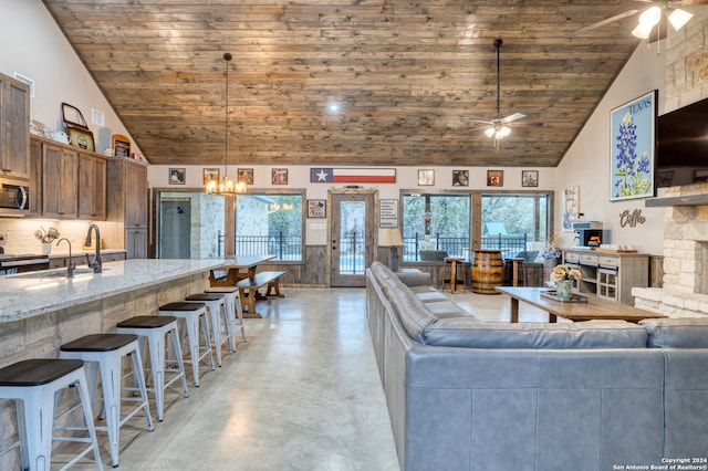 unfurnished living room with wood ceiling, sink, ceiling fan with notable chandelier, and high vaulted ceiling