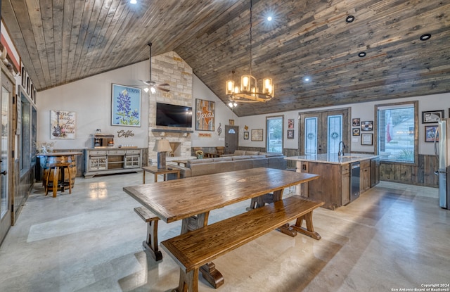 dining space with sink, ceiling fan with notable chandelier, high vaulted ceiling, and wooden ceiling