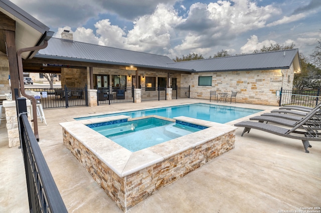 view of swimming pool featuring a patio area and an in ground hot tub