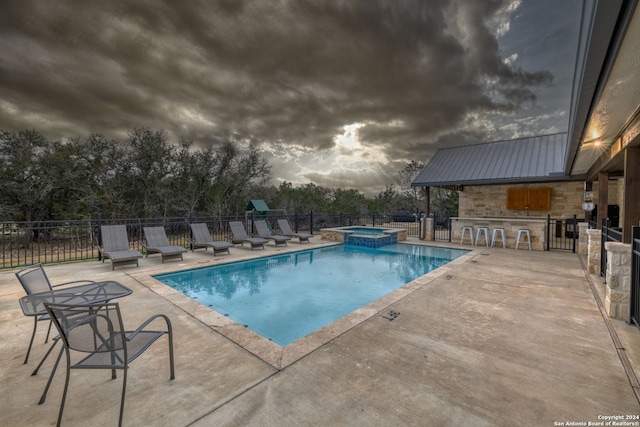 view of pool with a hot tub, a patio, and exterior bar