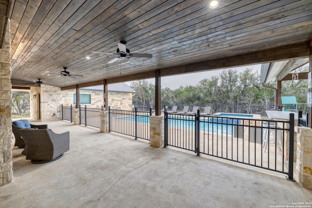 view of patio / terrace with ceiling fan and a fenced in pool