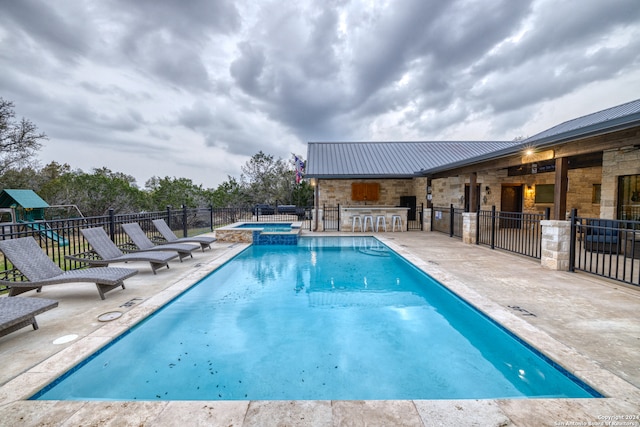 view of swimming pool with an in ground hot tub, an outdoor bar, and a patio