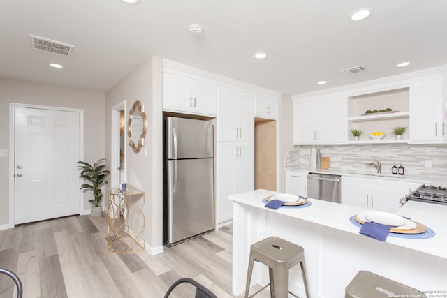 kitchen featuring light wood-type flooring, white cabinetry, and stainless steel appliances