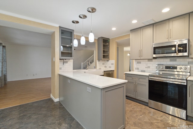 kitchen with stainless steel appliances, decorative light fixtures, gray cabinets, decorative backsplash, and kitchen peninsula