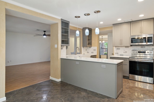 kitchen featuring dark wood-type flooring, kitchen peninsula, gray cabinets, pendant lighting, and appliances with stainless steel finishes