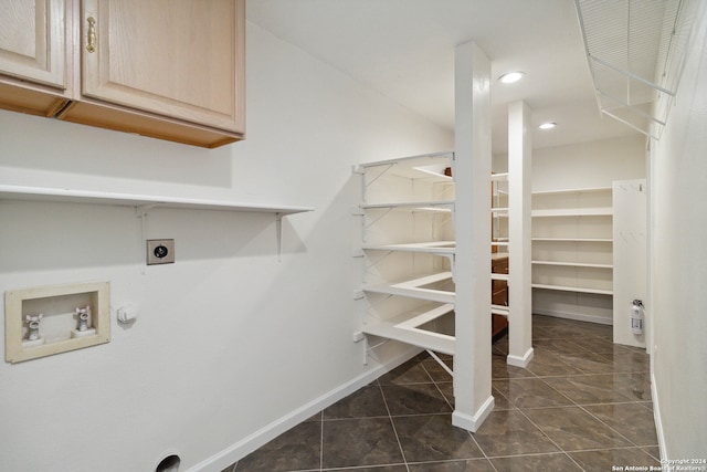 clothes washing area featuring cabinets, hookup for an electric dryer, hookup for a washing machine, hookup for a gas dryer, and dark tile patterned flooring