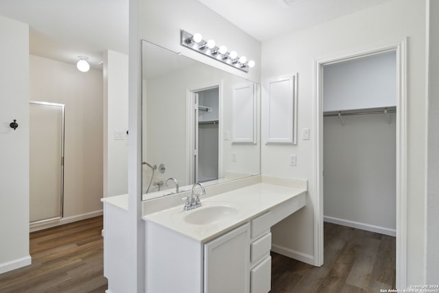 bathroom featuring an enclosed shower, vanity, and hardwood / wood-style flooring