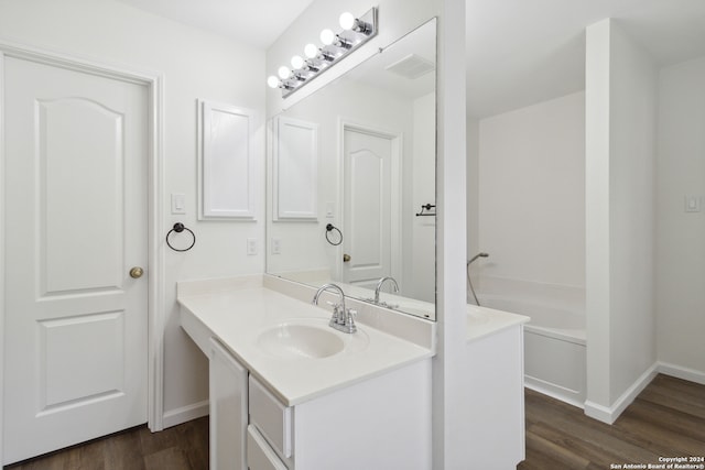 bathroom with a bathtub, vanity, and wood-type flooring