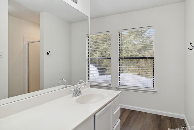 bathroom with a wealth of natural light, vanity, an enclosed shower, and hardwood / wood-style flooring