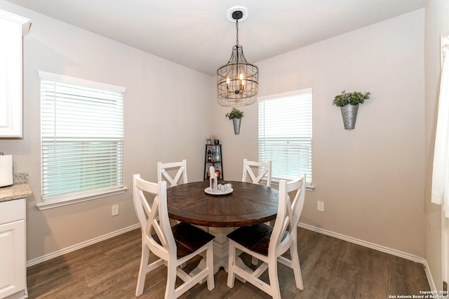 dining room featuring dark hardwood / wood-style flooring and an inviting chandelier