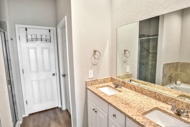 bathroom with hardwood / wood-style flooring, vanity, and shower with separate bathtub