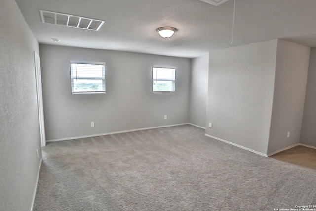 unfurnished room with a wealth of natural light and carpet flooring