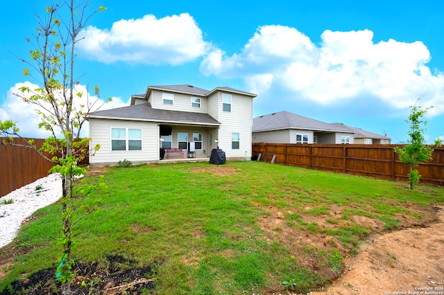 back of property featuring a yard and a patio area