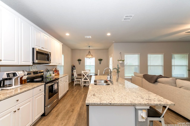 kitchen featuring stainless steel appliances, light hardwood / wood-style floors, white cabinetry, and sink