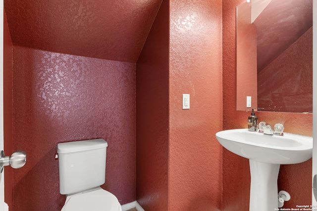 bathroom featuring toilet and lofted ceiling