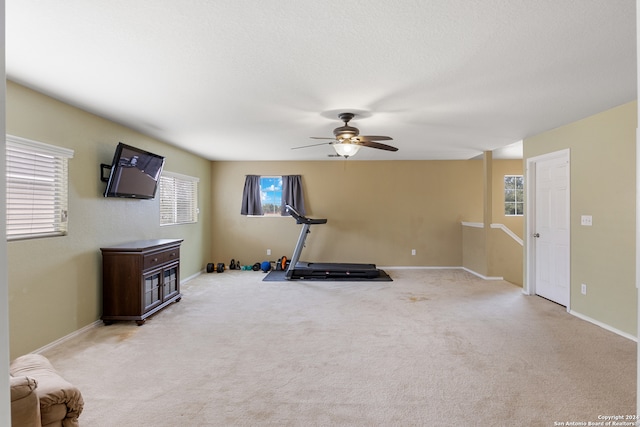 workout room featuring ceiling fan and light colored carpet