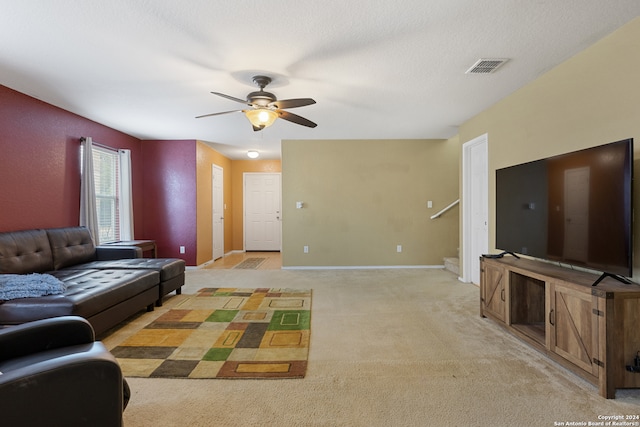 living room featuring a textured ceiling, light colored carpet, and ceiling fan