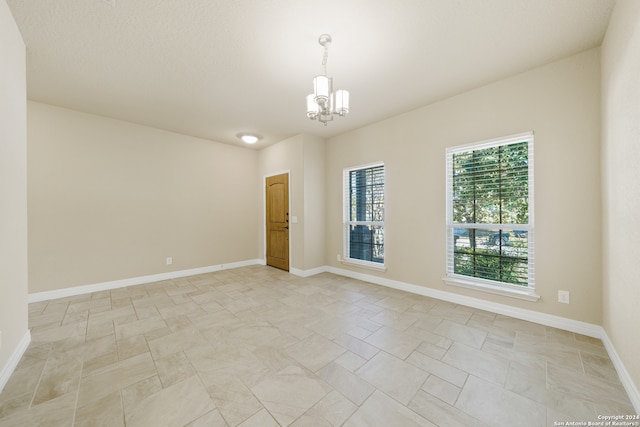 spare room featuring a notable chandelier