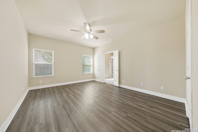 empty room with a textured ceiling, ceiling fan, and dark wood-type flooring