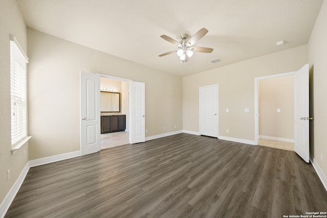 unfurnished bedroom with dark hardwood / wood-style flooring, ensuite bath, and ceiling fan