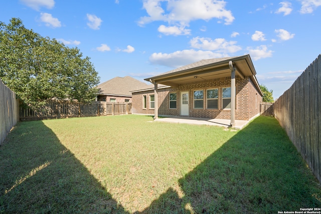 rear view of house featuring a yard and a patio area