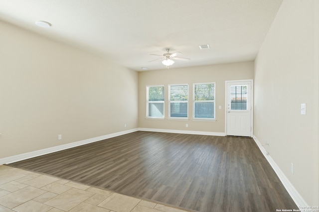 empty room with ceiling fan and light hardwood / wood-style flooring