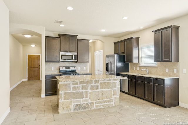 kitchen featuring a center island, appliances with stainless steel finishes, and tasteful backsplash