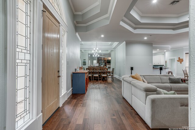 living room with ornamental molding, dark hardwood / wood-style flooring, and a chandelier