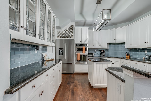 kitchen with stainless steel appliances, white cabinetry, backsplash, hanging light fixtures, and dark wood-type flooring