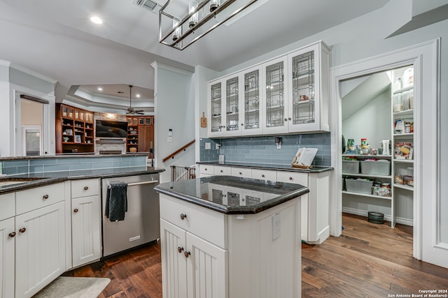 kitchen featuring dishwasher, decorative backsplash, white cabinets, dark hardwood / wood-style floors, and a kitchen island