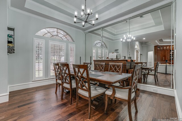 dining space featuring crown molding, dark hardwood / wood-style flooring, a notable chandelier, and a raised ceiling